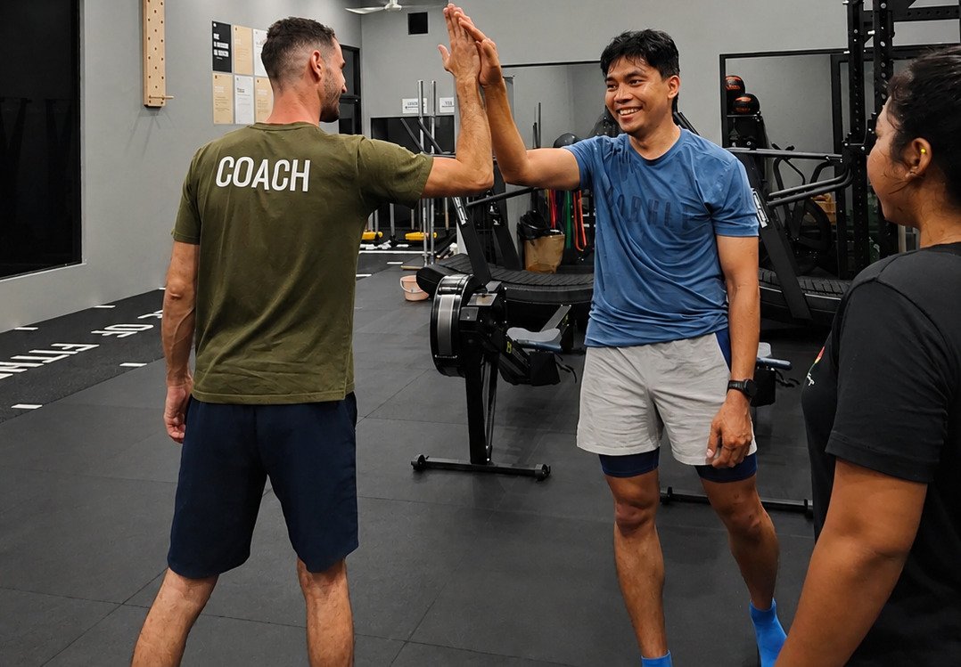 Bootcamp members high-fiving their coach at CrossFit Angkor