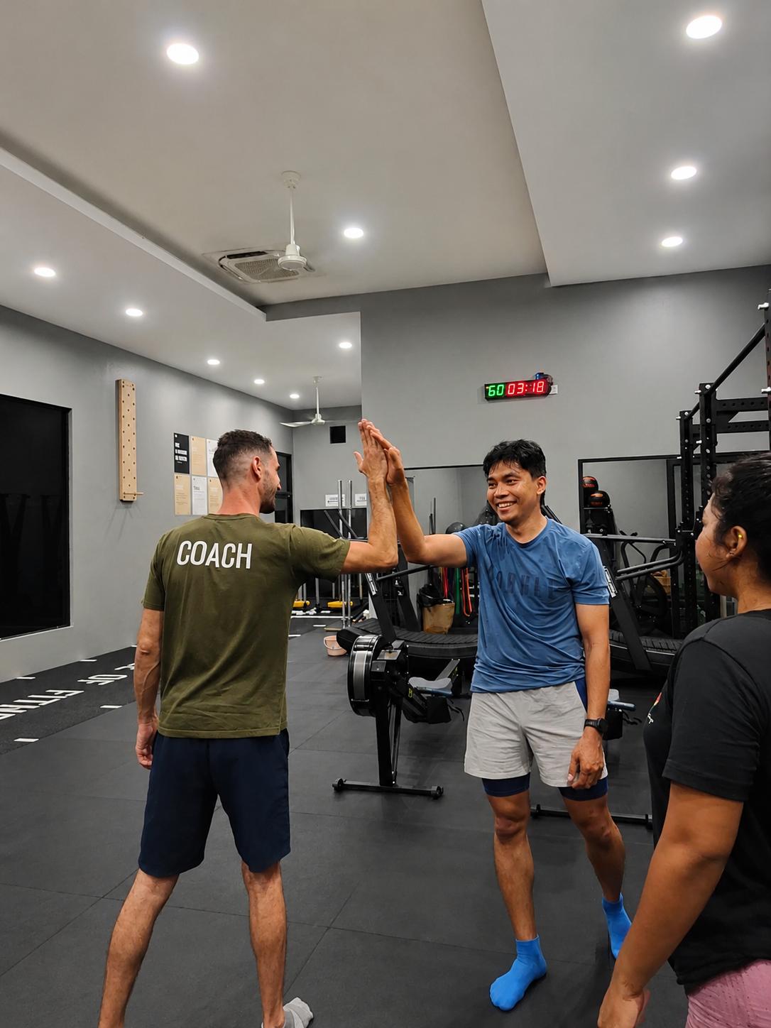 Coach and member high-fiving after class at CrossFit Angkor, Siem Reap